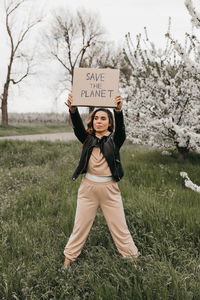 Full length of happy young woman standing on field