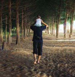 Full length rear view of man standing in forest