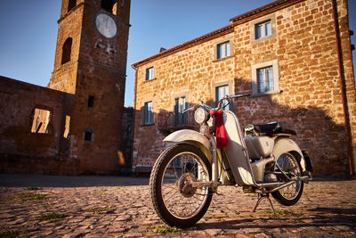 Vintage motorcycle in ghost town celleno in viterbo, sunset on the village