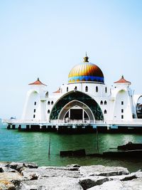 View of mosque and building against clear sky