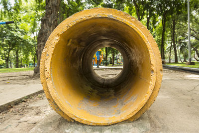 Yellow concrete pipe as tunnel of playground in lumpini park, bangkok, thailand