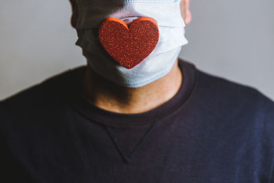 Close up of a man wearing a spongy heart on a face mask