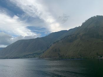 Scenic view of sea and mountains against sky