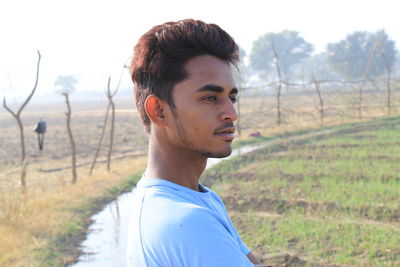 Portrait of young man standing on field