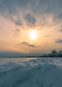 Scenic view of snow covered land during sunset