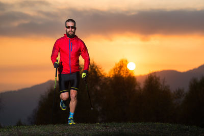 Portrait of man standing against orange sky