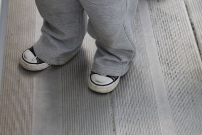 Low section of man standing on hardwood floor