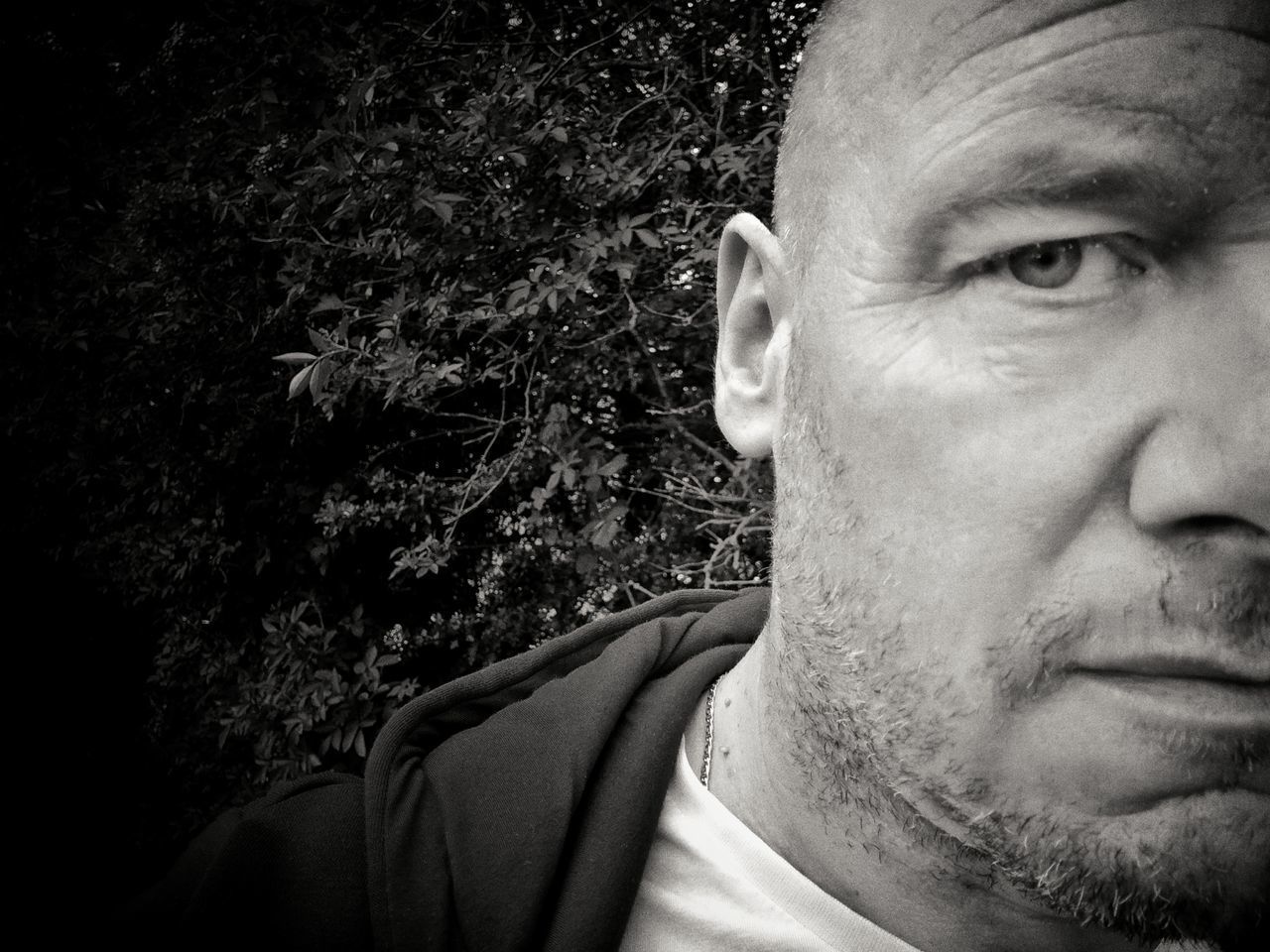 CLOSE-UP PORTRAIT OF MAN LOOKING AWAY WHILE STANDING OUTDOORS