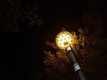 Low angle view of illuminated lights against trees at night