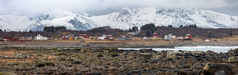 Group of people on snow covered land against sky