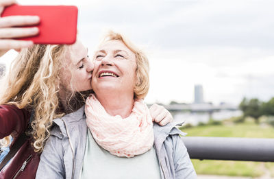 Grandmother and granddaughter taking selfie with smartphone