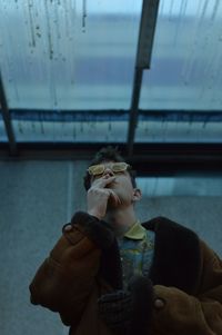 Man smoking cigarette against ceiling