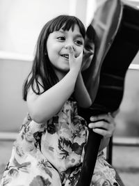 Smiling girl looking at ukelele