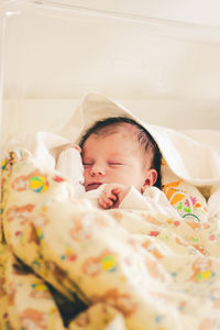 Cute baby boy sleeping on bed at home