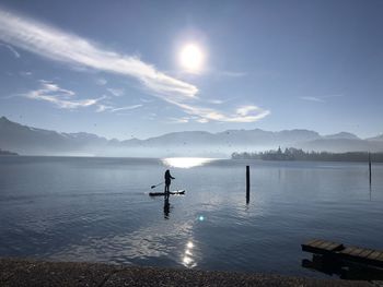 Silhouette person in lake against sky