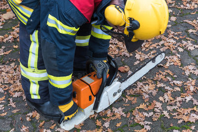 High angle view of firefighter holding chainsaw