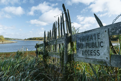 Information sign on beach against sky