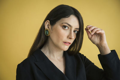 Portrait of a young woman against yellow background