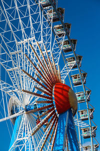 Low angle view of ferris wheel against blue sky