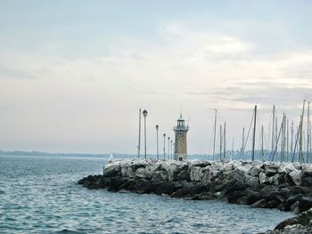 Lighthouse by lake garda against sky