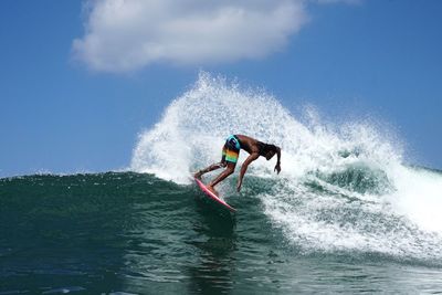 Man surfing on sea against sky