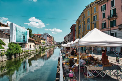 Panoramic view of buildings by canal against sky in city