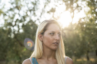 Close-up portrait of young woman against tree