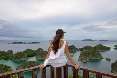 Rear view of woman looking at sea against sky