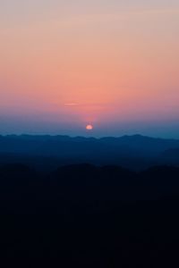 Scenic view of silhouette mountains against romantic sky at sunset