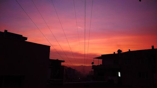 Low angle view of silhouette buildings against sky at sunset