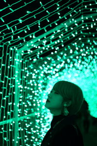 Woman standing against illuminated lights