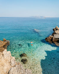 Man floating on water on beautiful beach with turquoise water on pag island in croatia.