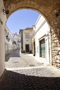 Alley amidst buildings in town against clear sky