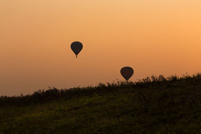 Scenic view of hot air balloon taking off at sunset