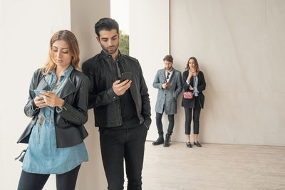 Young couple standing on mobile phone