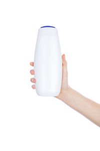 Midsection of woman holding bottle against white background
