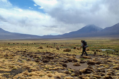 Man walking on landscape against sky