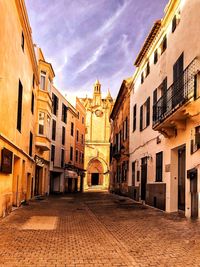 Street amidst buildings in town against sky