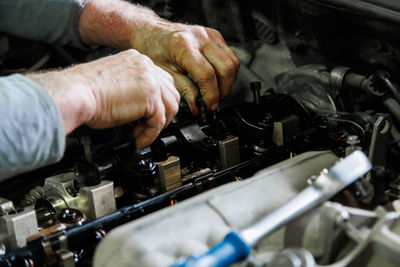 Cropped hand of mechanic repairing car