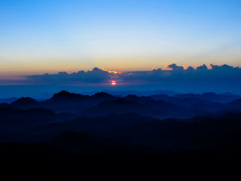 Scenic view of silhouette mountains against sky during sunset