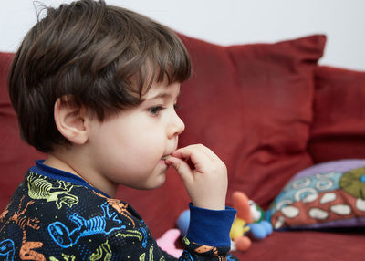 Close-up of cute boy eating food at home