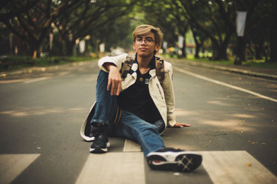 Full length of young man skateboarding on road