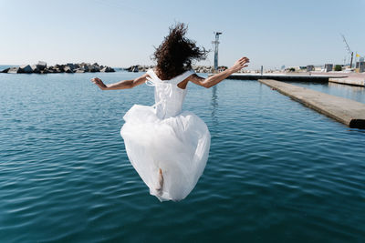 Rear view of woman in sea against sky