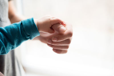 Close-up of baby holding person hands