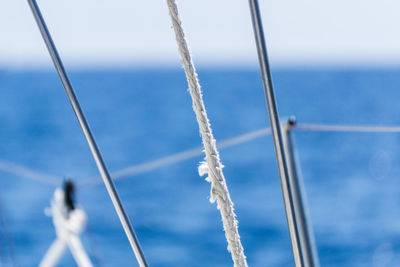 Close-up of sailboat sailing on sea against sky