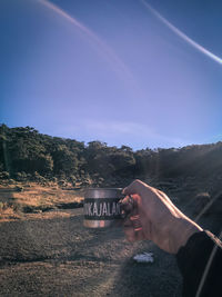 Person holding umbrella against clear sky