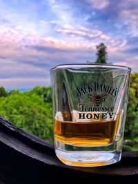 Close-up of beer glass on table against sky