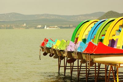 Multi colored deck chairs on beach against sky