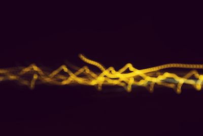 Close-up of illuminated lights over black background