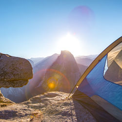 Scenic view of mountains against blue sky on sunny day